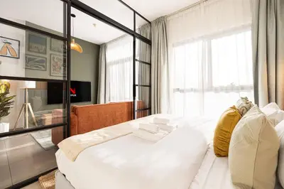 a bedroom with a large white bed and a window at Urbane 1BR in Dubai Hills in Dubai