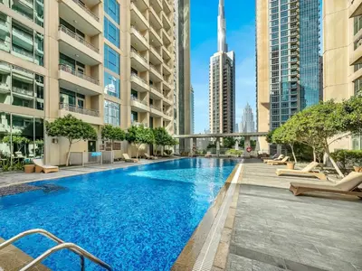 a swimming pool in the middle of a city with tall buildings at Stylish 1BR - Burj Khalifa View in Dubai