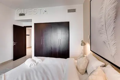a bedroom with a white bed and a black door at The Views & Greens - Mosela Tower, Dubai in Dubai