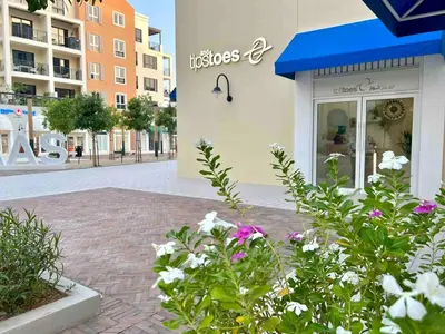 a store with a blue awning and flowers in front at 50 Shades of Grey Luxury Apartment near Beach in Dubai