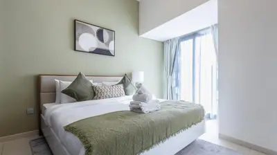 a bedroom with a bed with white sheets and a window at Breathtaking Marina 2BR in Iconic Cayan Tower - 7AB08 in Dubai