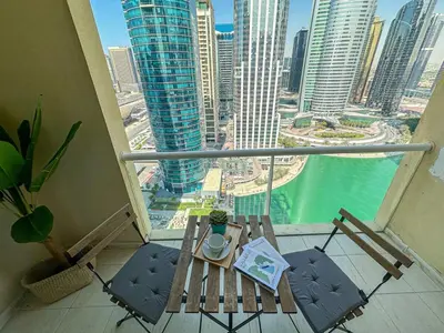 a balcony with a table and chairs and a view of a city at Higuest - Lake-view Studio in JLT in Dubai