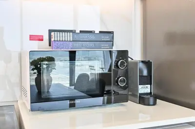 a microwave oven sitting on a counter with a television at Stunning 1 Bdr luxury residence at JVC in Dubai