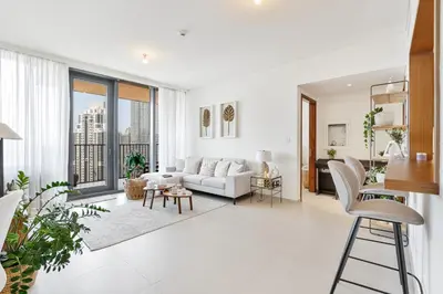 a living room with a couch and a table at Stylish 1BR with Pool, Gym, BBQ Area & Playground in Dubai