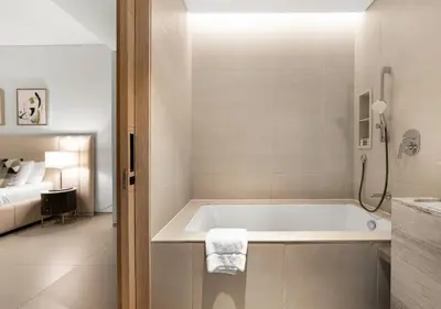 a white bathroom with a tub and a bed at Address Residences Stay in Dubai