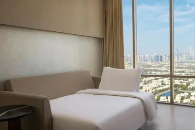 a hotel room with a bed and a large window at Hotel Local Dubai, Jumeirah Village Triangle, Autograph Collection in Dubai