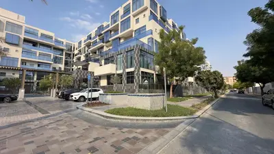 a building on a street with cars parked in front of it at Elite Business & Family Turnkey 433 Residence 2BR in OIA Motor City in Dubai