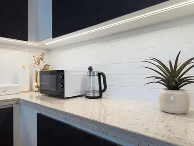 a kitchen counter with a microwave and a potted plant at Elite Business & Family Turnkey 433 Residence 2BR in OIA Motor City in Dubai