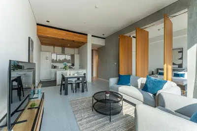 a living room with a couch and a table at HAVN - 1 Bed at KOA Canvas, Access to Nasab Dubai in Dubai