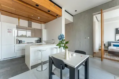 a kitchen and living room with a table and chairs at HAVN - 1 Bed at KOA Canvas, Access to Nasab Dubai in Dubai