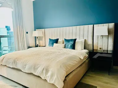 a bedroom with a large bed with a blue wall at Dubai I Burj Residence Retreat I Piano & Workstation in Dubai