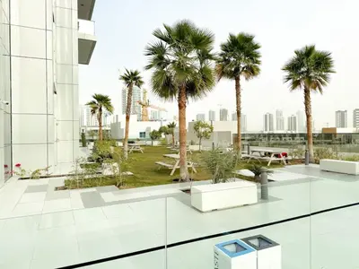 a courtyard with palm trees in a building at Modern Studio Living in JVC's Regina Tower in Dubai