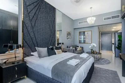 a bedroom with a large bed and a living room at Modern furnishing City Centre Super speed wifi in Dubai
