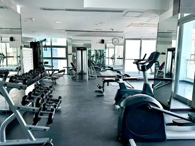 a gym with rows of treadms and cardio machines at Cozy Studio at DEC Tower in Dubai