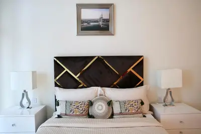 a bedroom with a bed with a wooden headboard at Nivis find-Affordable & Spacious 1 BHK- 10 Mins to Dubai Mall in Dubai