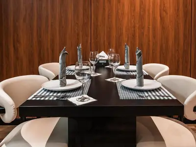 a table with white chairs and a black table with wine glasses at D Stays holiday homes 1min walk to Dubai mall & Burj Khalifa in Dubai