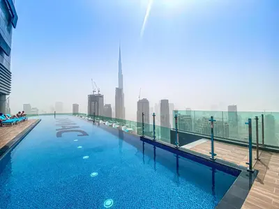 a swimming pool on the roof of a building with a city at Exclusive 1BR with Iconic Views in Paramount Tower in Dubai