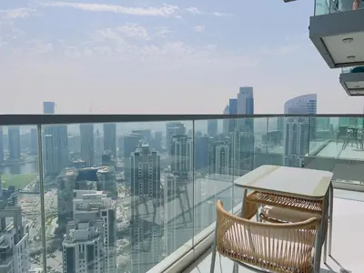 a chair on a balcony with a view of the city at Exclusive 1BR with Iconic Views in Paramount Tower in Dubai