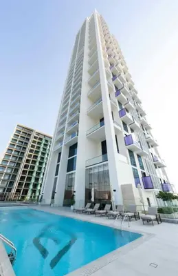 a large building with a swimming pool in front of it at Modern Studio Apt Balcony & Free Parking Jvc in Dubai