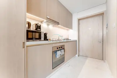 a kitchen with a stove top oven next to a door at High-Rise Studio Overlooking the Sea with a Glimpse of Ain Dubai, The Palm Tower, Palm Jumeirah by Deluxe Holiday Homes in Dubai