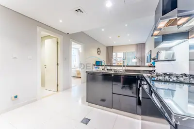 a large kitchen with a large counter top at Pool and City View 1BR Near Dubai Water Canal, The Cosmopolitan, Business Bay by Deluxe Holiday Homes in Dubai