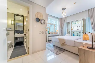 a bedroom with a large bed and a bathroom at Pool and City View 1BR Near Dubai Water Canal, The Cosmopolitan, Business Bay by Deluxe Holiday Homes in Dubai