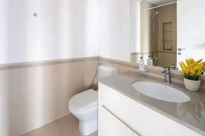 a white bathroom with a toilet and a sink at Frank Porter - Hayat Boulevard 2B in Dubai