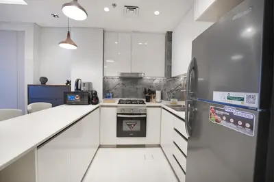 a kitchen with a stove and a refrigerator at EasyGo- Luxury 1BR with Burj Khalifa view and lavish Amenities in Dubai