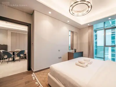 a bedroom with a large bed and a dining room at Modern 1-Bed Apartment in a Prime Central Location in Dubai