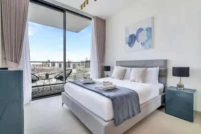 a bedroom with a large bed and a large window at Exceptional 1BR flat wBalcony Gym & Pool in JVC in Dubai