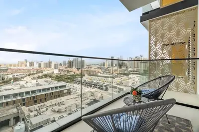 a balcony with two chairs and a view of a city at Exceptional 1BR flat wBalcony Gym & Pool in JVC in Dubai