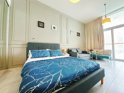 a bedroom with a bed with a blue comforter at Luxury Oasis - Burj Khalifa Views in Dubai