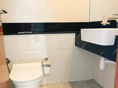 a bathroom with a white toilet and a sink at Luxury Oasis - Burj Khalifa Views in Dubai