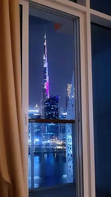 a view of a city at night from a window at Luxury Oasis - Burj Khalifa Views in Dubai