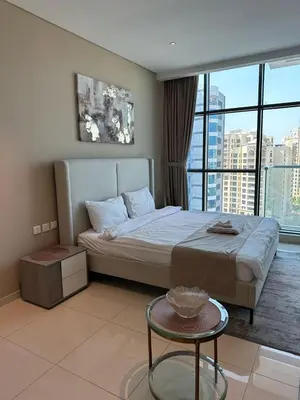 a bedroom with a bed with a table and a window at Seven Palm west beach Studio in Dubai