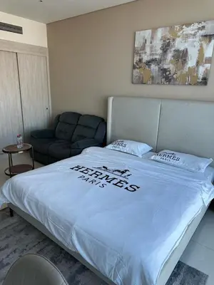 a bedroom with a white bed with a couch at Seven Palm west beach Studio in Dubai