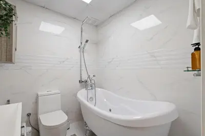 a white bathroom with a toilet and a sink at High Floor Upgraded 2BR in JLT - Walk to Lake Park in Dubai