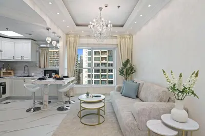 a living room with a couch and a kitchen at High Floor Upgraded 2BR in JLT - Walk to Lake Park in Dubai