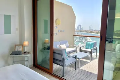 a hotel room with a balcony with a bed and chairs at Upgraded & Cozy Boutique Studio in Palm Jumeirah PV7 in Dubai