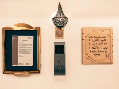 a wall with a picture and a vase and a sign at New Fairmont Residence Private Beach club access Palm Jumeirah in Dubai