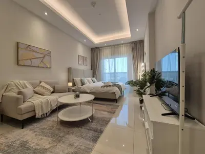 a living room with a couch and a table at Studio in Hera towers, Dubai sports city in Dubai