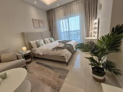 a bedroom with a bed and a potted plant at Studio in Hera towers, Dubai sports city in Dubai