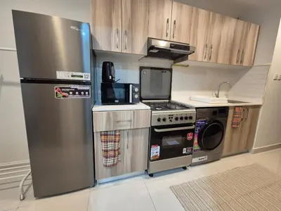 a kitchen with a stainless steel refrigerator and a microwave at Studio in Hera towers, Dubai sports city in Dubai
