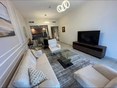 a living room with a couch and a flat screen tv at 1 bedroom apartment in Jumeirah in Dubai