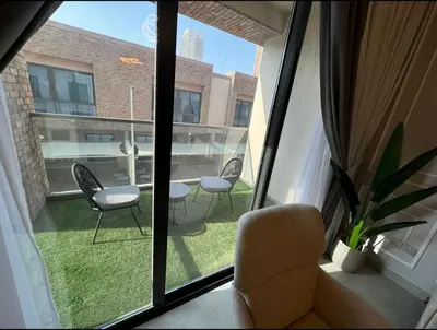 a room with a window with chairs and a table at 1 bedroom apartment in Jumeirah in Dubai