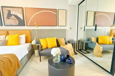 a bedroom with a bed and a couch and a table at Top Floor Studio with Sofa Bed Walk to Dubai Mall by Vibel in Dubai