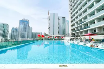 a large swimming pool in a city with buildings at Top Floor Studio with Sofa Bed Walk to Dubai Mall by Vibel in Dubai