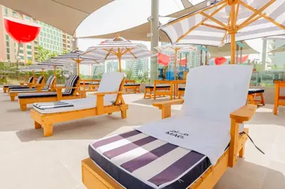 a group of chairs and umbrellas on a patio at Top Floor Studio with Sofa Bed Walk to Dubai Mall by Vibel in Dubai