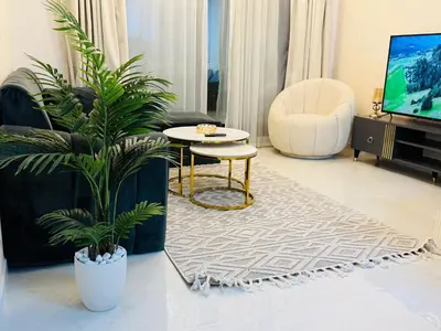 a living room with a tv and a table and plants at 1BHK LUXURY PRIVATE APARTMENT - Dubai Marina - 2 MIN WALK FROM TRAM in Dubai