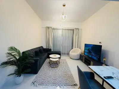 a living room with a black couch and a tv at 1BHK LUXURY PRIVATE APARTMENT - Dubai Marina - 2 MIN WALK FROM TRAM in Dubai